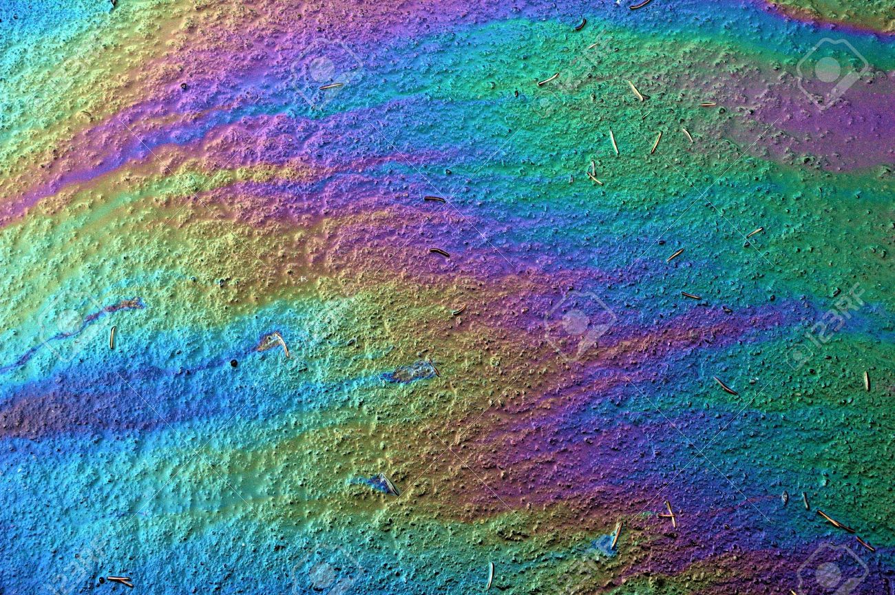 14237984-Gasoline-that-had-leaked-onto-a-wet-parking-lot-creates-a-rainbow-oil-slick-Stock-Photo.jpg