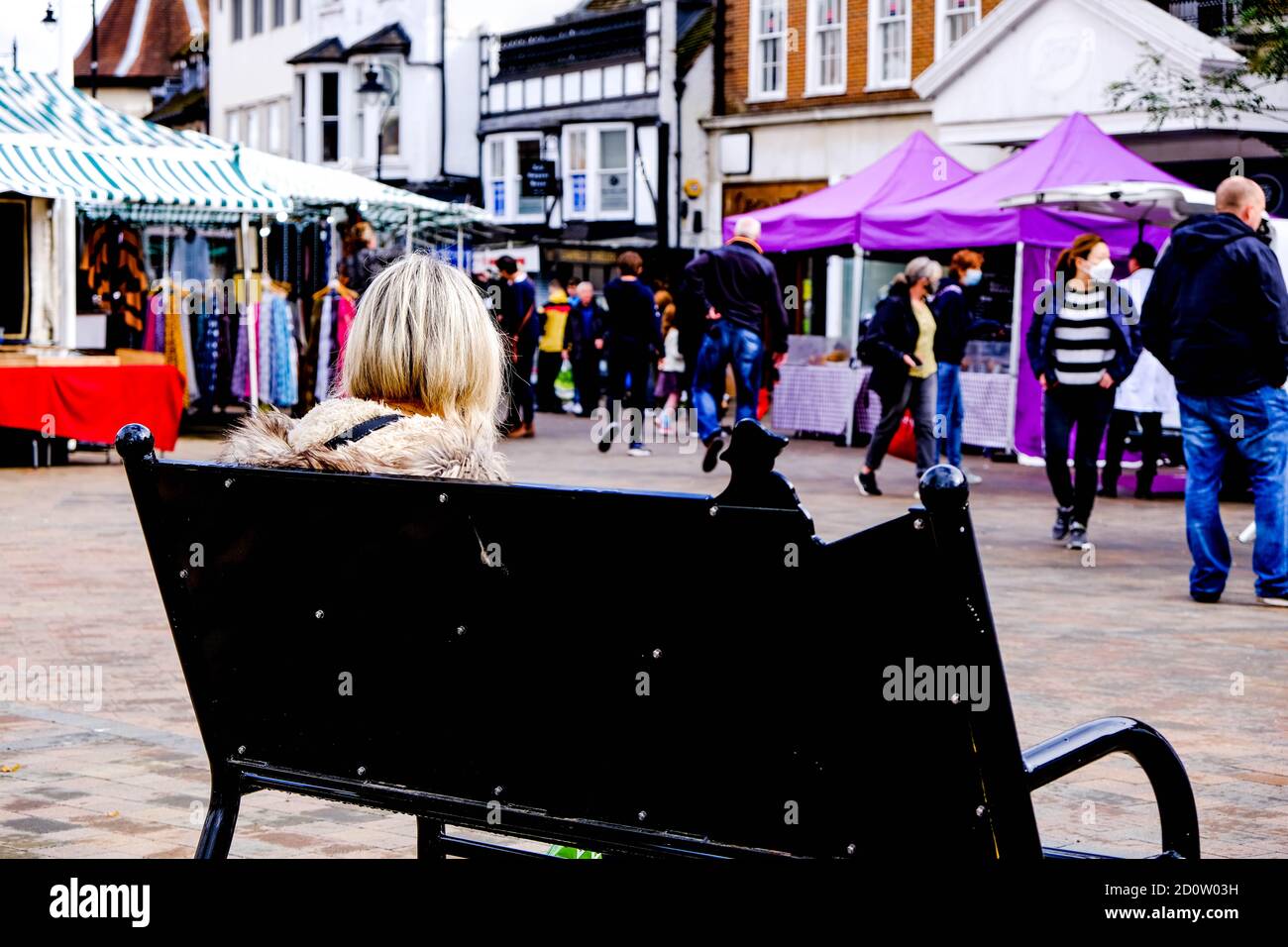 london-uk-october-03-2020-woman-sitting-alone-in-epsom-market-people-watching-during-covid-19-2D0W03H.jpg