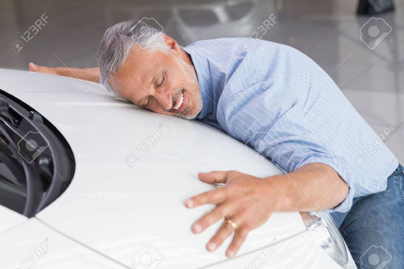 36390213-smiling-man-hugging-a-white-car-at-new-car-showroom.jpg