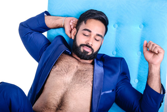 Attractive Asian young bearded hairy sleepy male model in blue suit  stretching on sofa Stock Photo | Adobe Stock